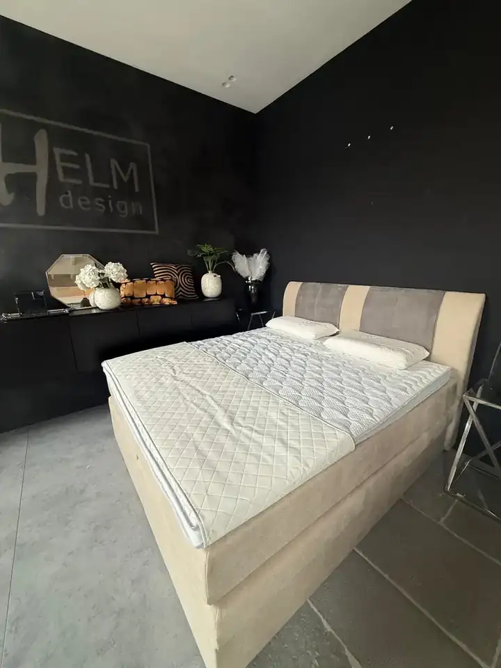 Boxspringbett mit zweifarbigem Kopfteil im HELM Showroom